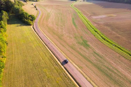 vue aérienne d’une voiture roulant sur une route de campagne pour le voyage vue aérienne d'une voiture roulant sur une route de campagne pour le voyage