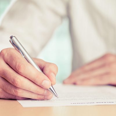 Sign Businessman signing a document. Tinted photo, shallow depth of field.