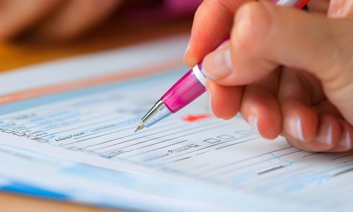 Close-up of a hand filling out a form with a pen. The photo captures the details of the process and emphasizes the importance of carefulness. Close-up of a hand filling out a form with a pen. The photo captures the details of the process and emphasizes the importance of carefulness.